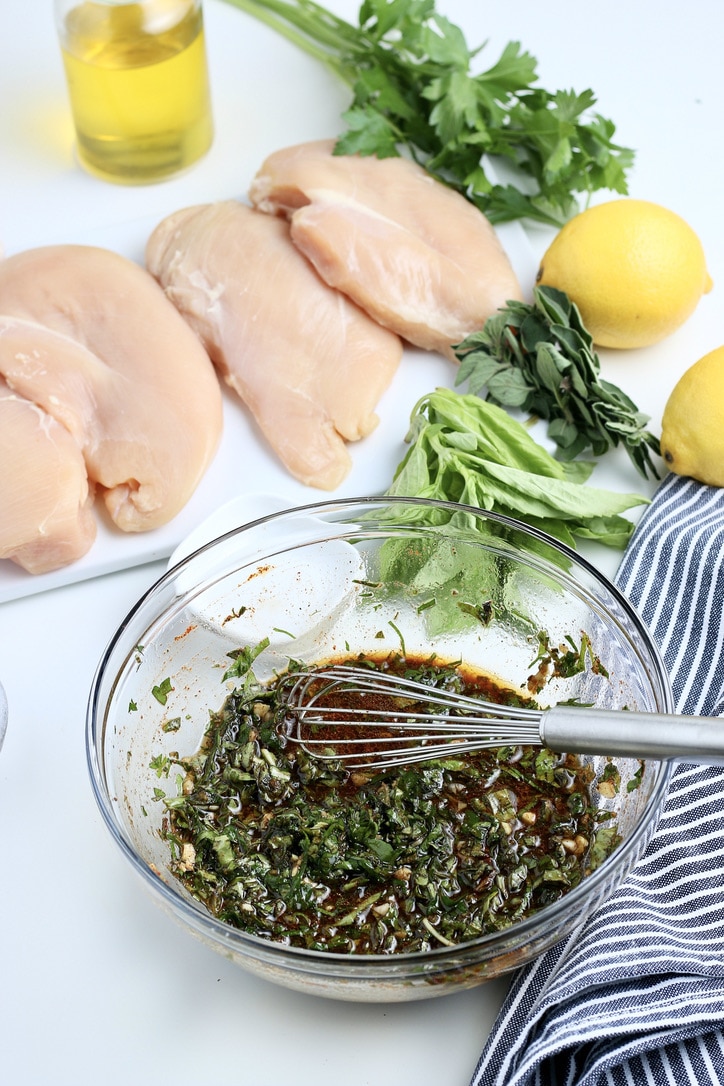A mixture of marinade for chicken breasts in a clear mixing bowl.