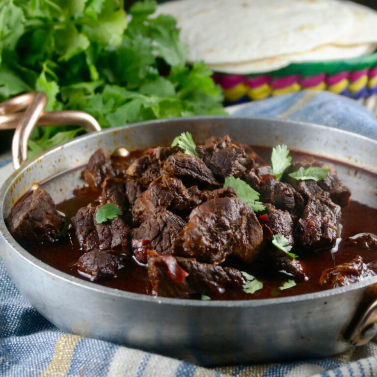 Authentic chili colorado cooked in an Instant Pot in a stainless serving dish.