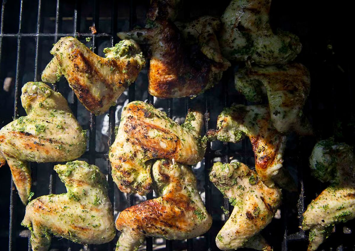 Charred and saucy grilled chicken wings piled on a plate.