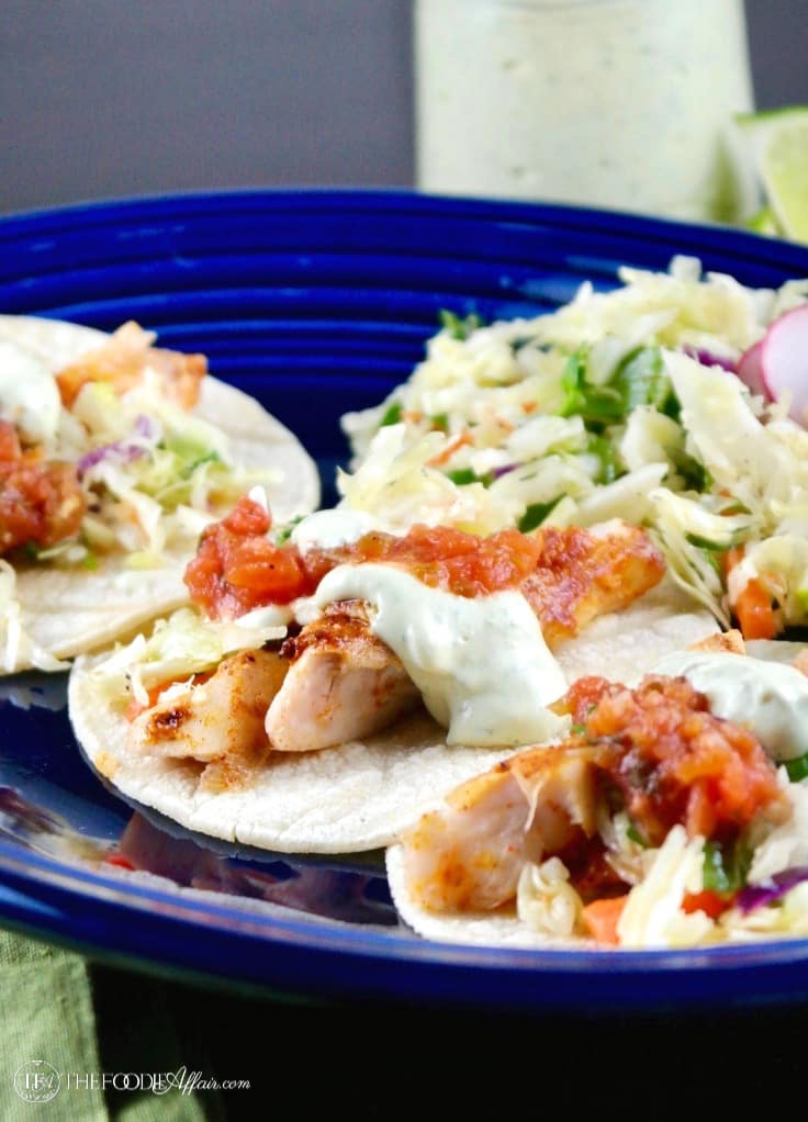Healthy Fish Tacos recipe with fresh caught cod topped with salsa, avocado cream and slaw.