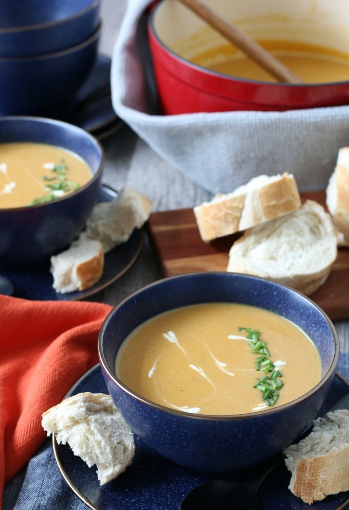 Sweet potato soup with curry finished and ready to be eaten, dished out into bowls with bread.