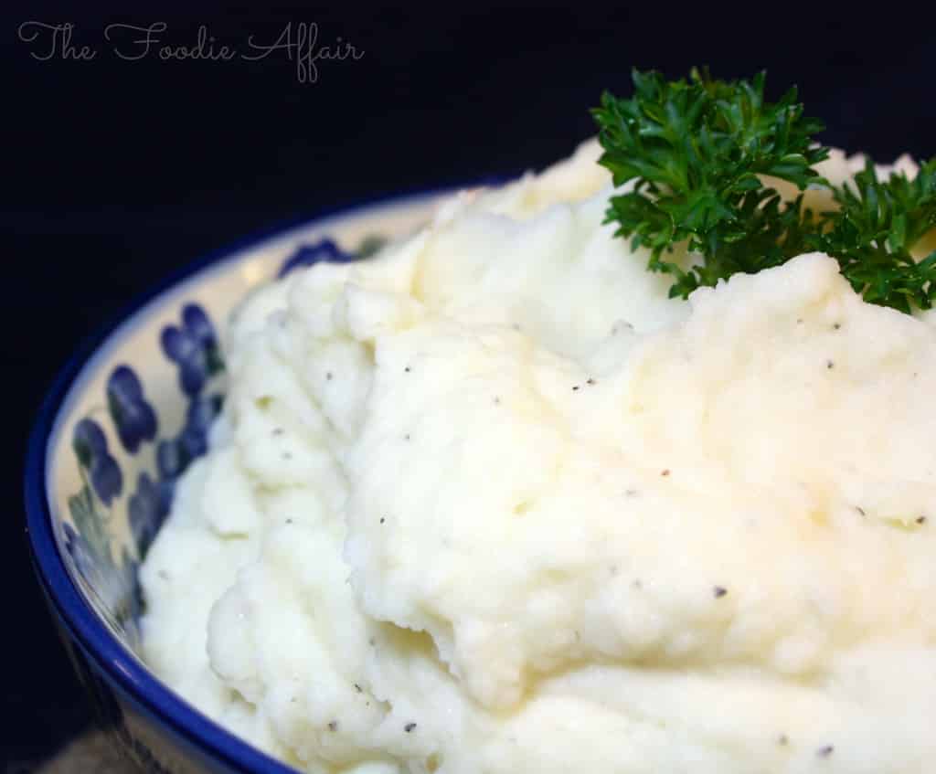 Fluffy Whipped Potatoes in a serving bowl topped with parsley
